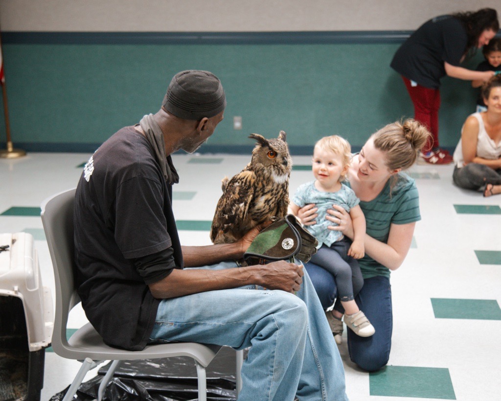 A child engages with an owl during a program at the Lynchburg Public Library.